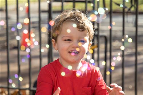 Toddler Playing with Bubbles Outside